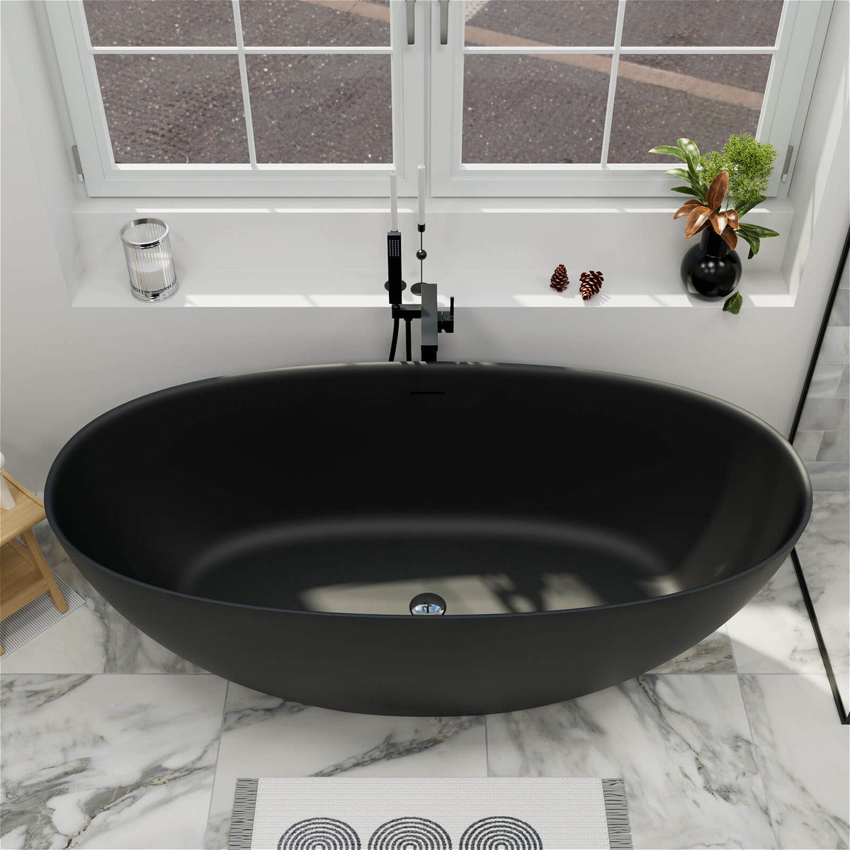 Black oval freestanding bathtub with visible center drain