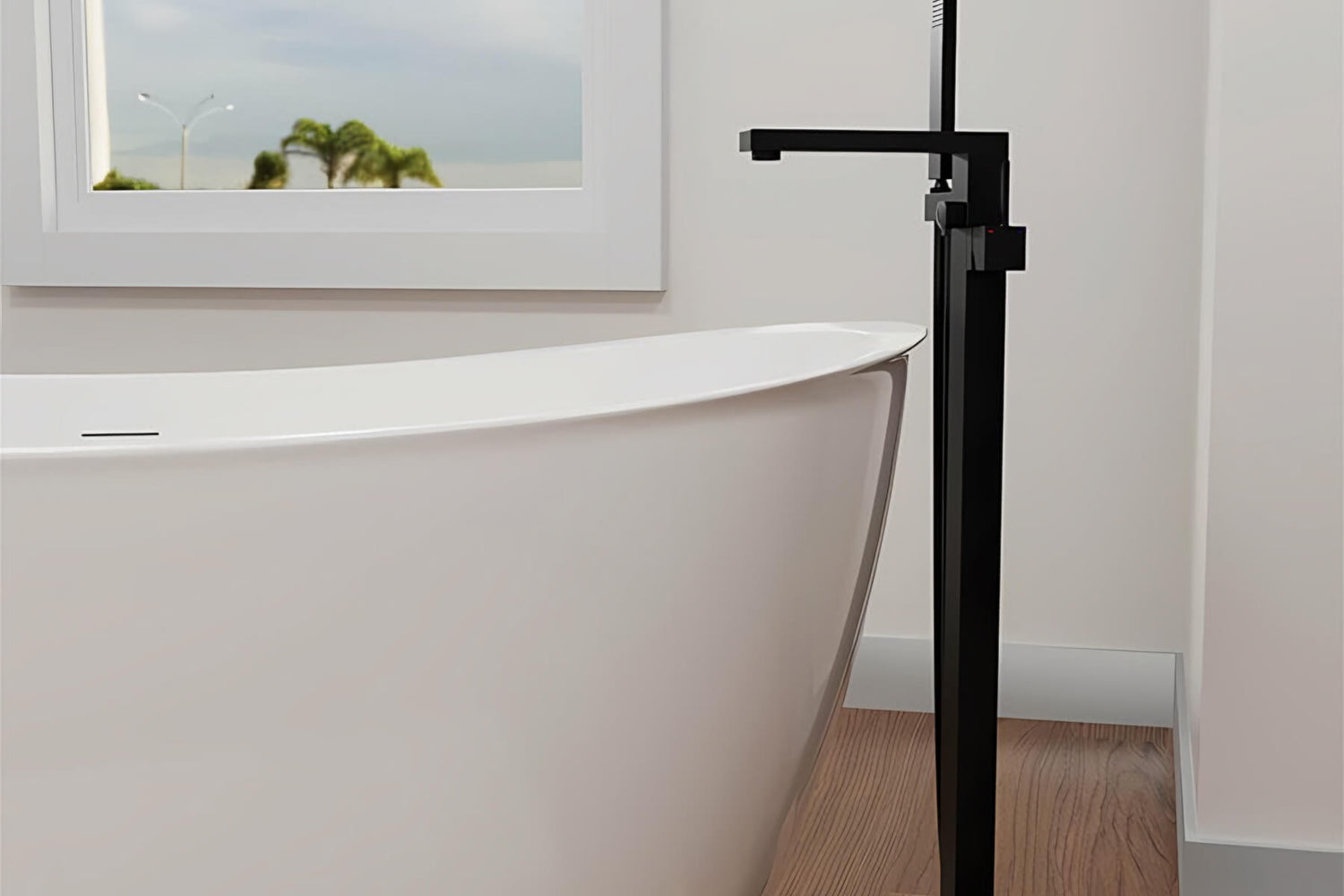 A black freestanding faucet is placed next to the bathtub