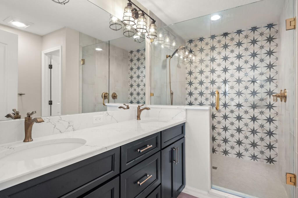 A dark gray-purple vanity beautifully complemented by bronze fixtures, industrial lighting, and a retro-style sink that nod to classic design