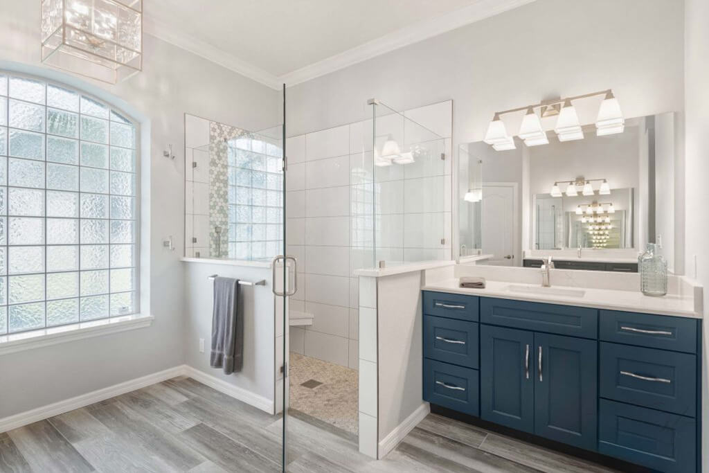A navy blue-gray vanity adds bold contrast against a soft