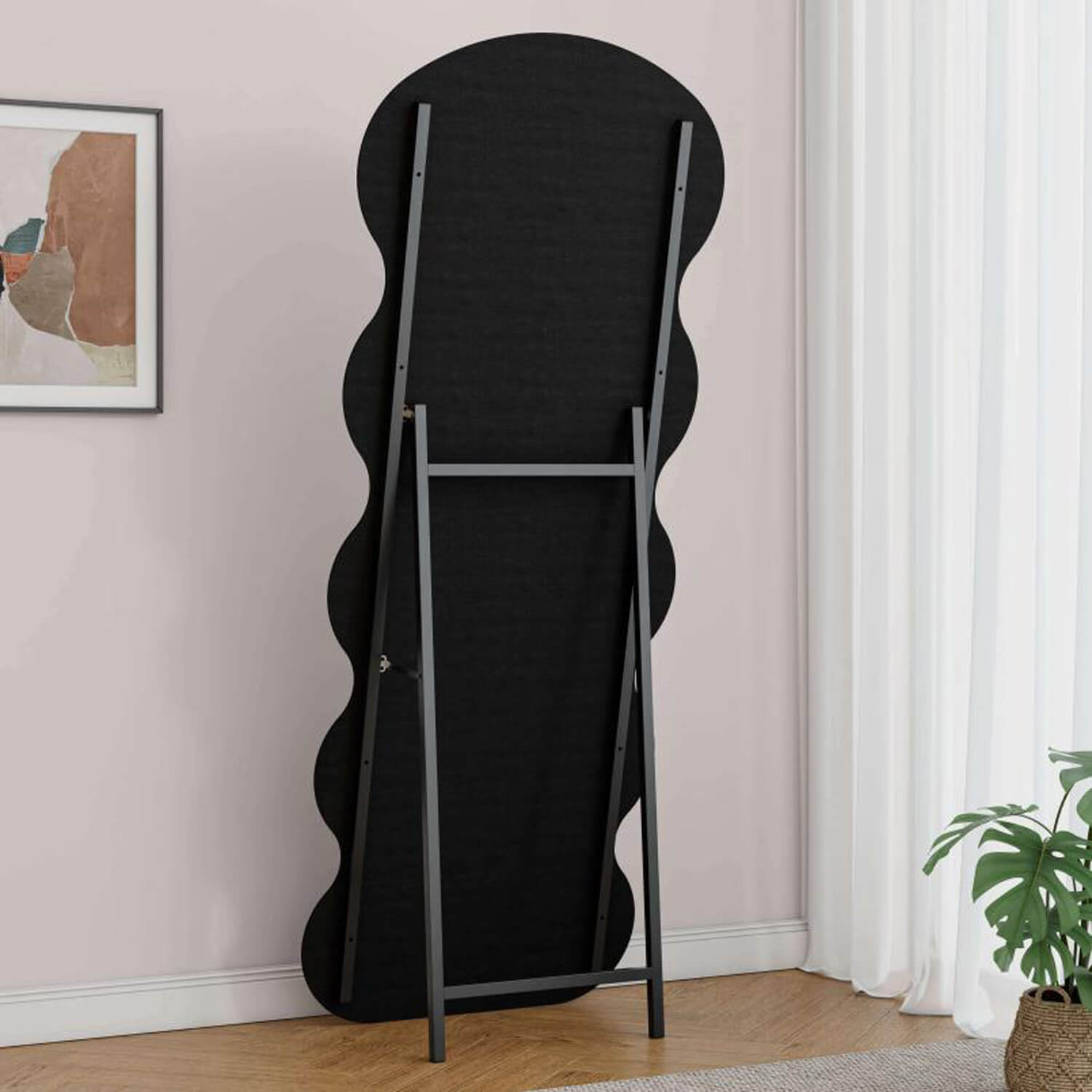 Back view of black wavy mirror with freestanding metal bracket