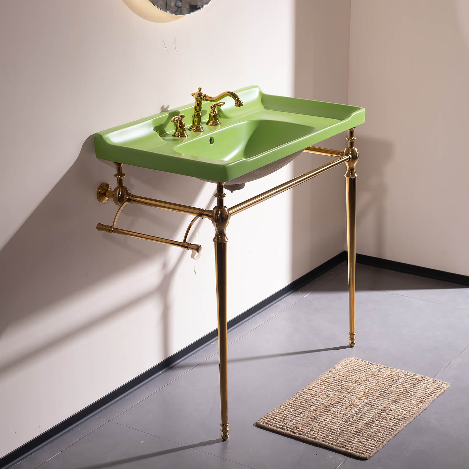 Console style bathroom sink with gold legs and deep green ceramic basin
