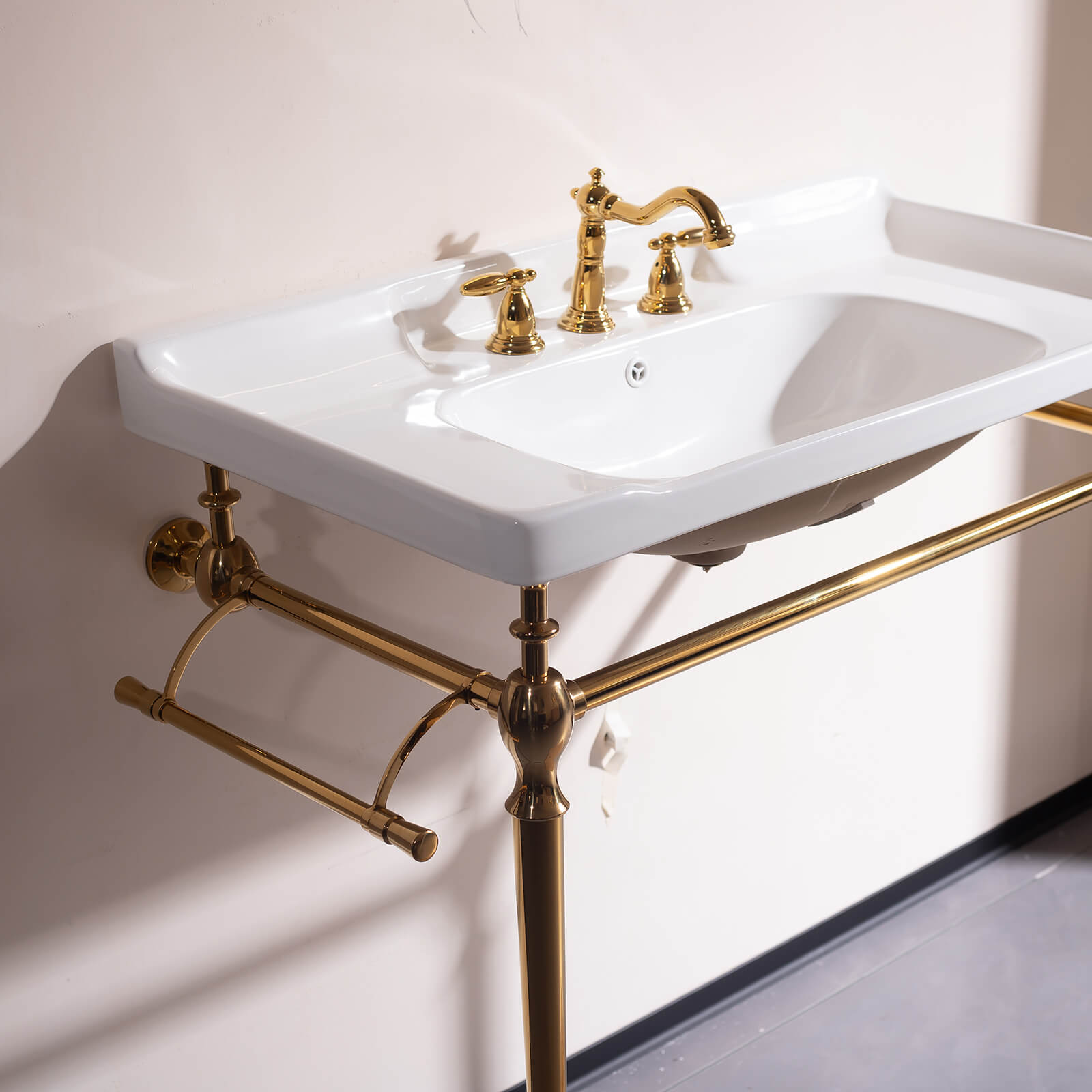 Console style bathroom sink with gold legs and white ceramic basin timeless design