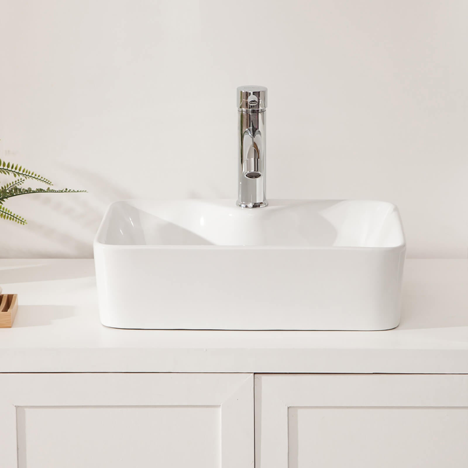 Glossy white bathroom sink reflecting ambient vanity lighting
