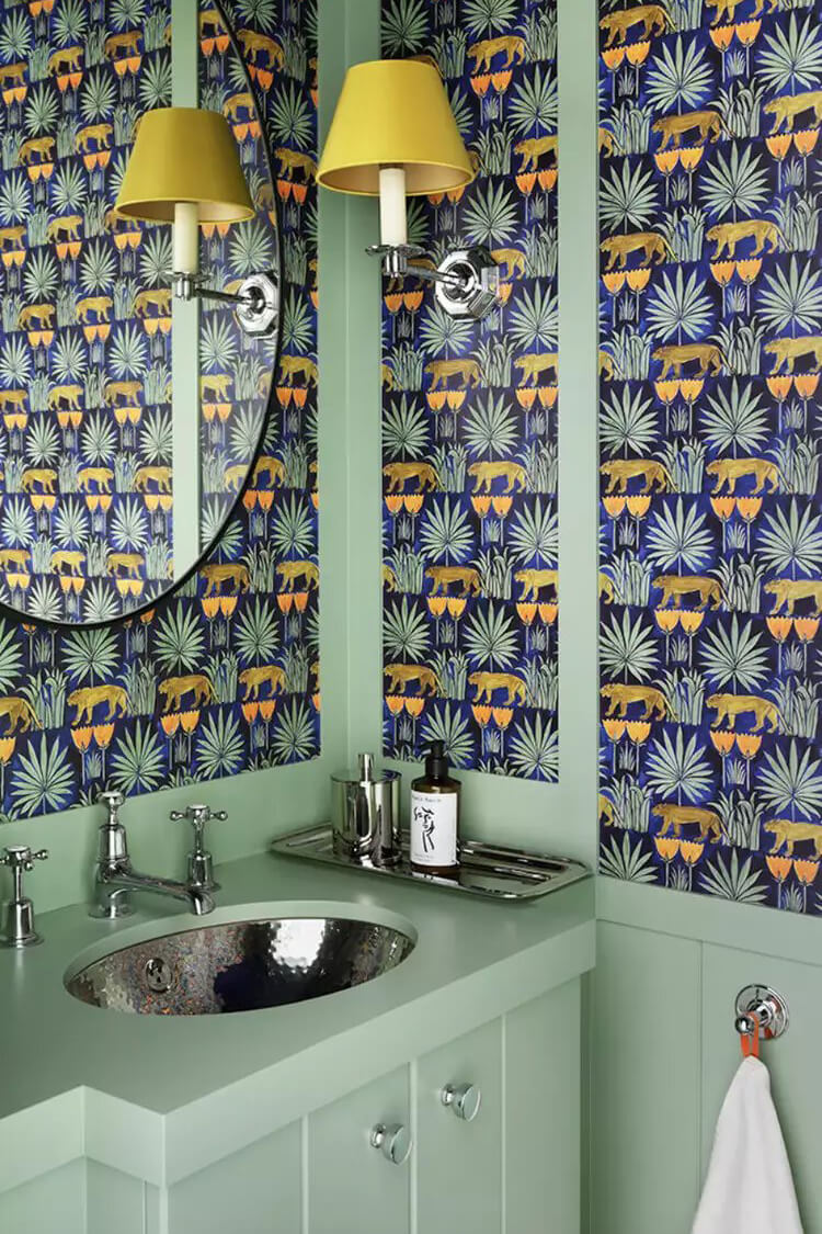 Moss-green cabinets and matching wainscoting bring a lively yet grounded feel to this bathroom