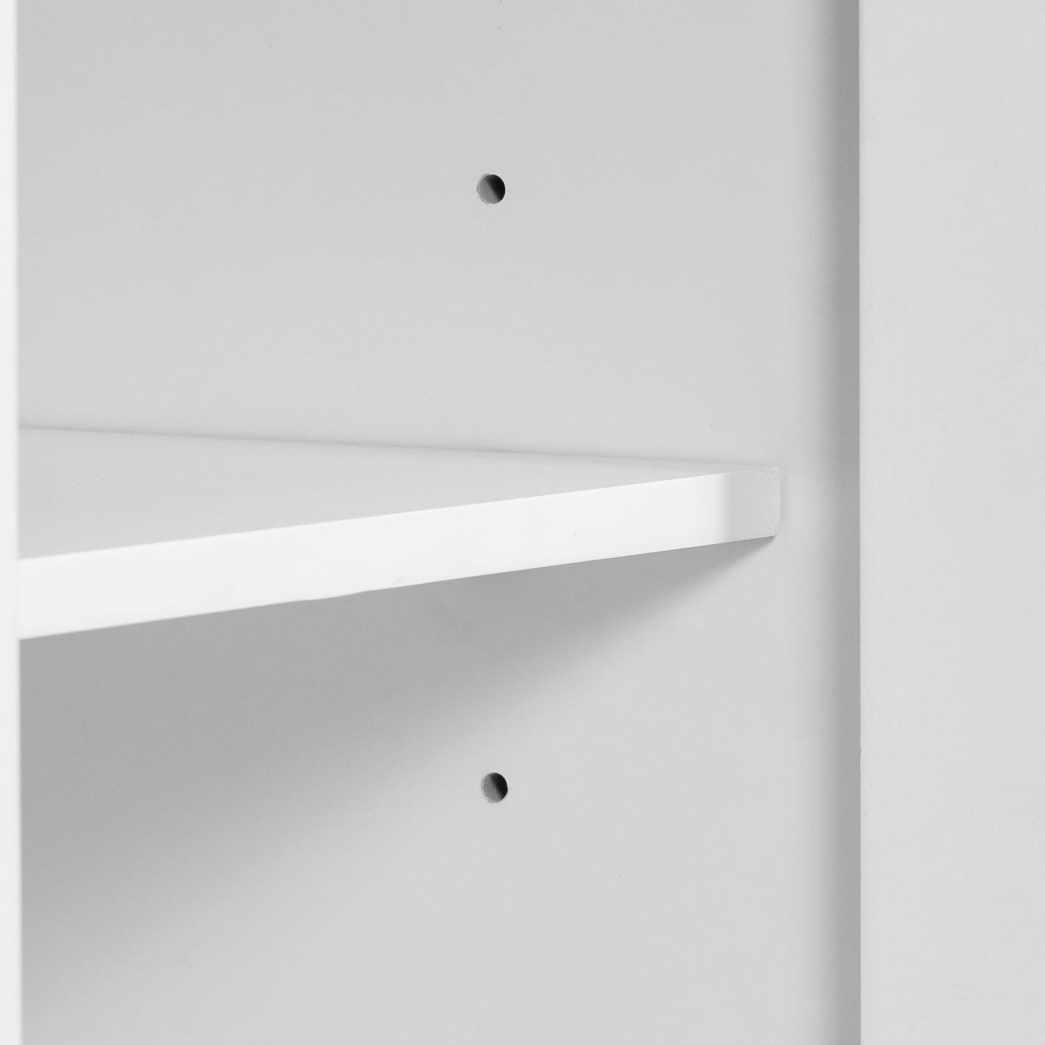 Open cabinet door showing adjustable shelves in white bathroom vanity