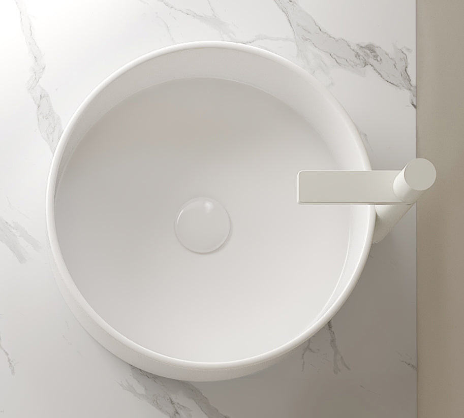 Round white ceramic above-counter vessel bathroom sink with smooth surface, central drain opening, and ceramic construction