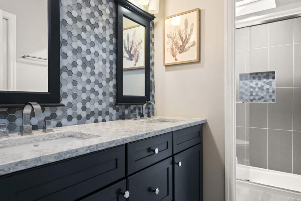 Try pairing a dark charcoal-blue vanity with a patterned tile backsplash in complementary tones