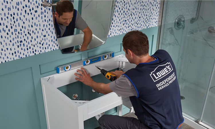 A man installing a bathroom vanity