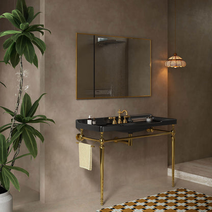 Angled bathroom view of a 48-inch black ceramic console sink with gold legs and a side towel bar.