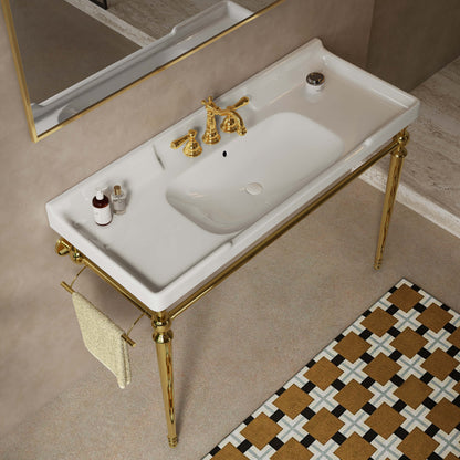 Overhead view of a 48-inch white ceramic console sink with gold legs and a side towel bar in a bathroom.