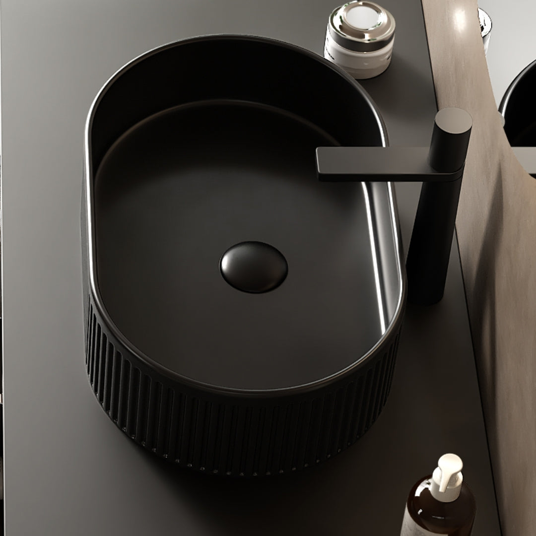 Black oval ceramic vessel bathroom sink with textured striped exterior, smooth interior, and above-counter installation