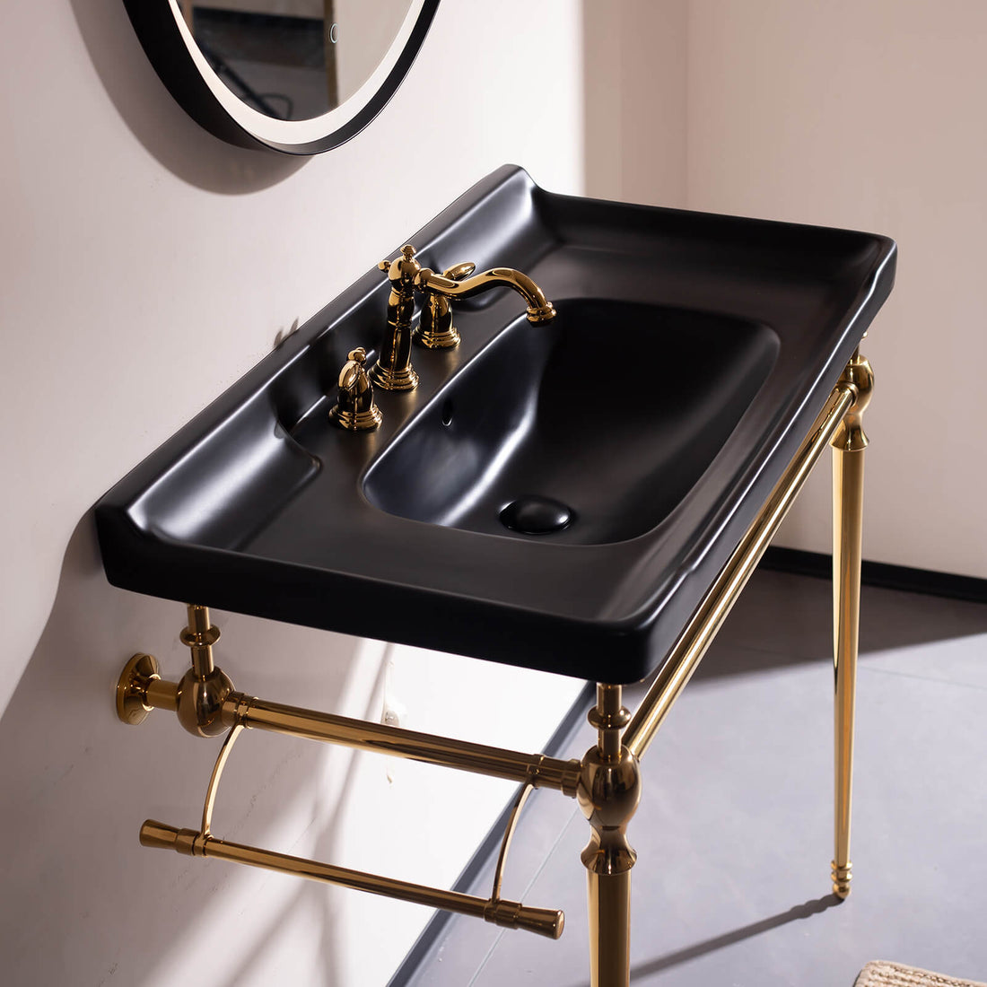 Console style bathroom sink with gold metal legs and black ceramic basin   hotel inspired design