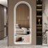 Cool white light arched LED mirror against wooden panel wall