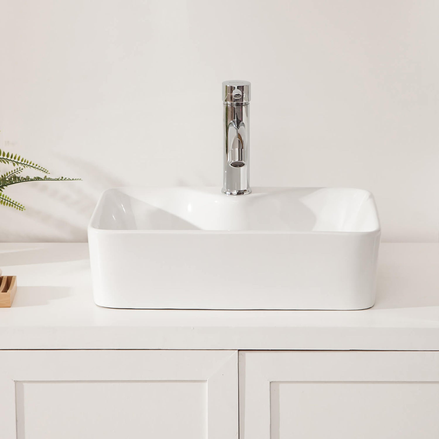 Glossy white bathroom sink reflecting ambient vanity lighting
