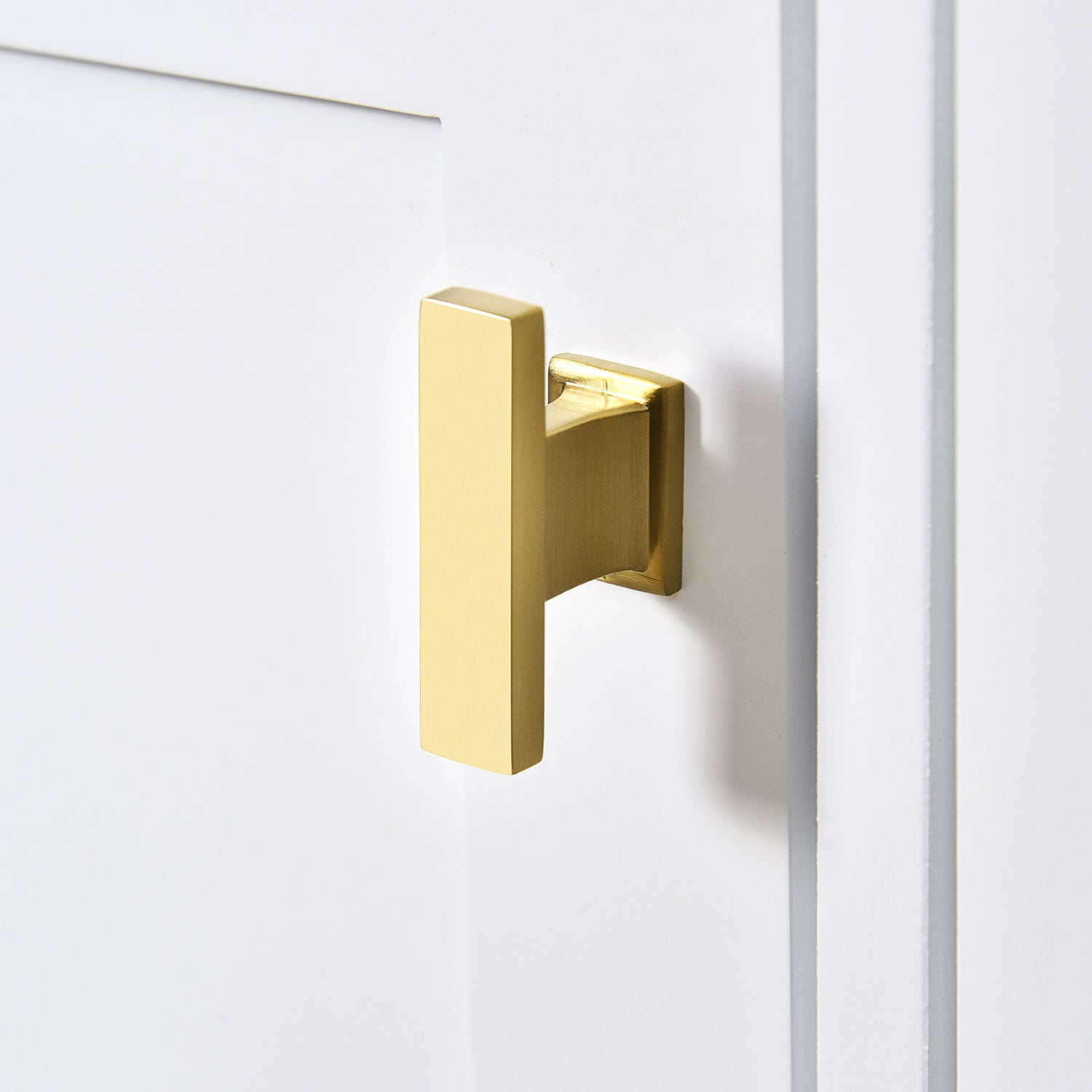Gold cabinet handle of the white bathroom vanity door