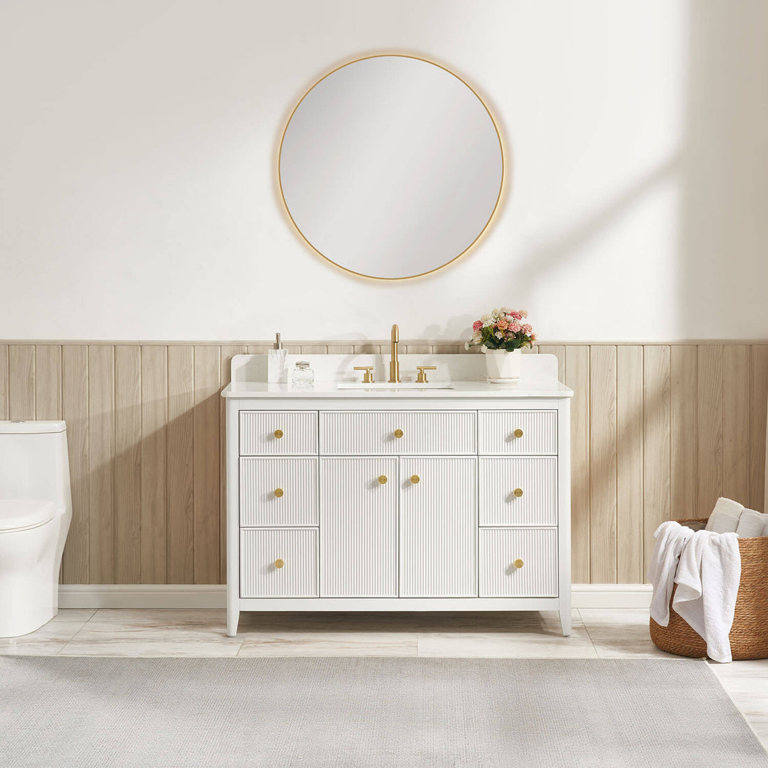 White freestanding bathroom vanity with fluted doors and brushed gold hardware