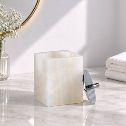 White jade marble cotton swab storage jar with removable chrome lid on a bathroom countertop
