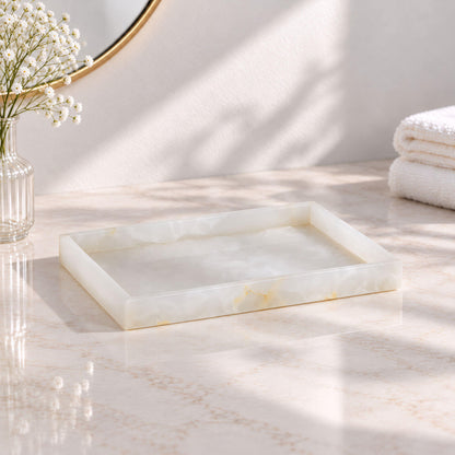 Rectangular white jade marble vanity tray with raised edges on a bathroom countertop